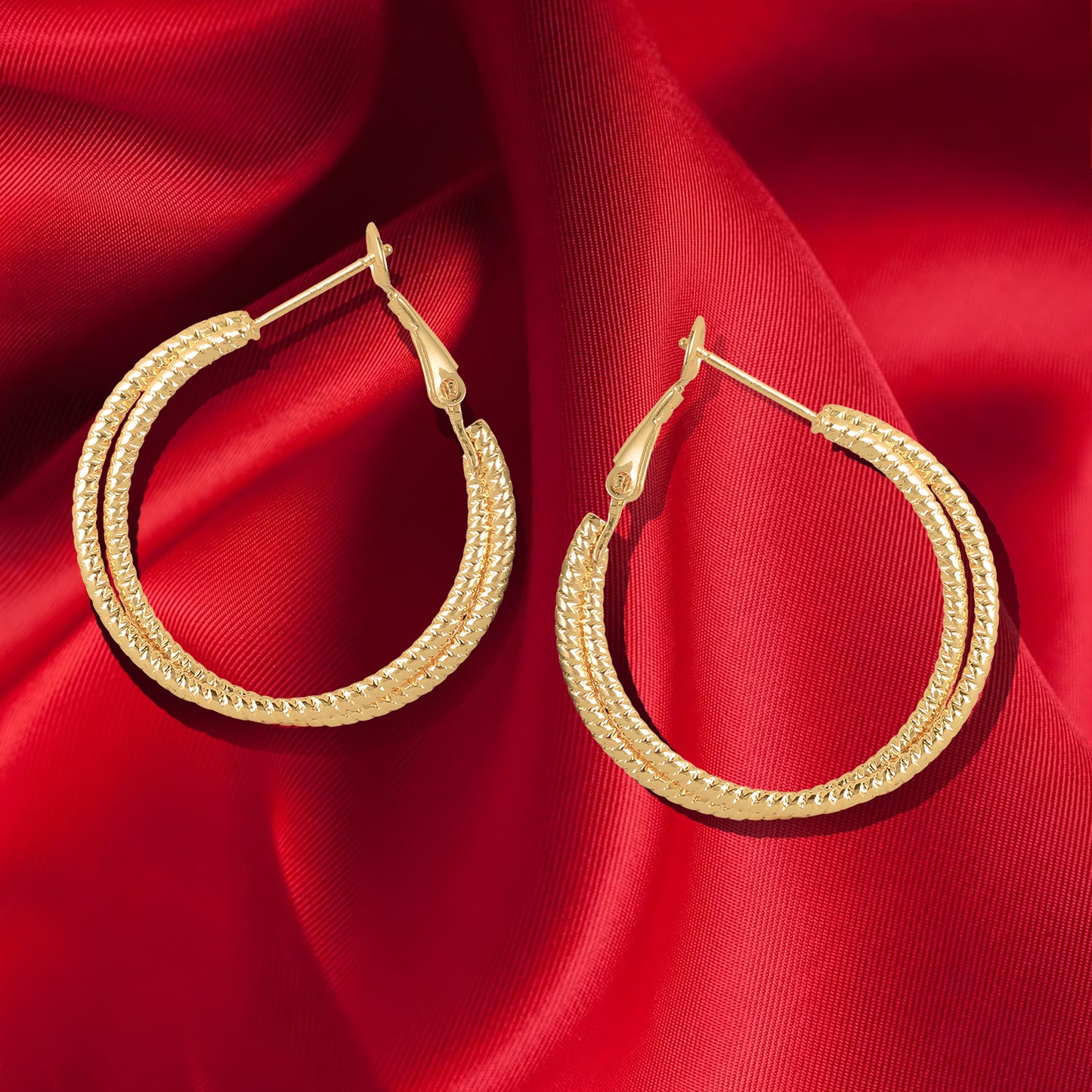 criss cross hoop earrings red background