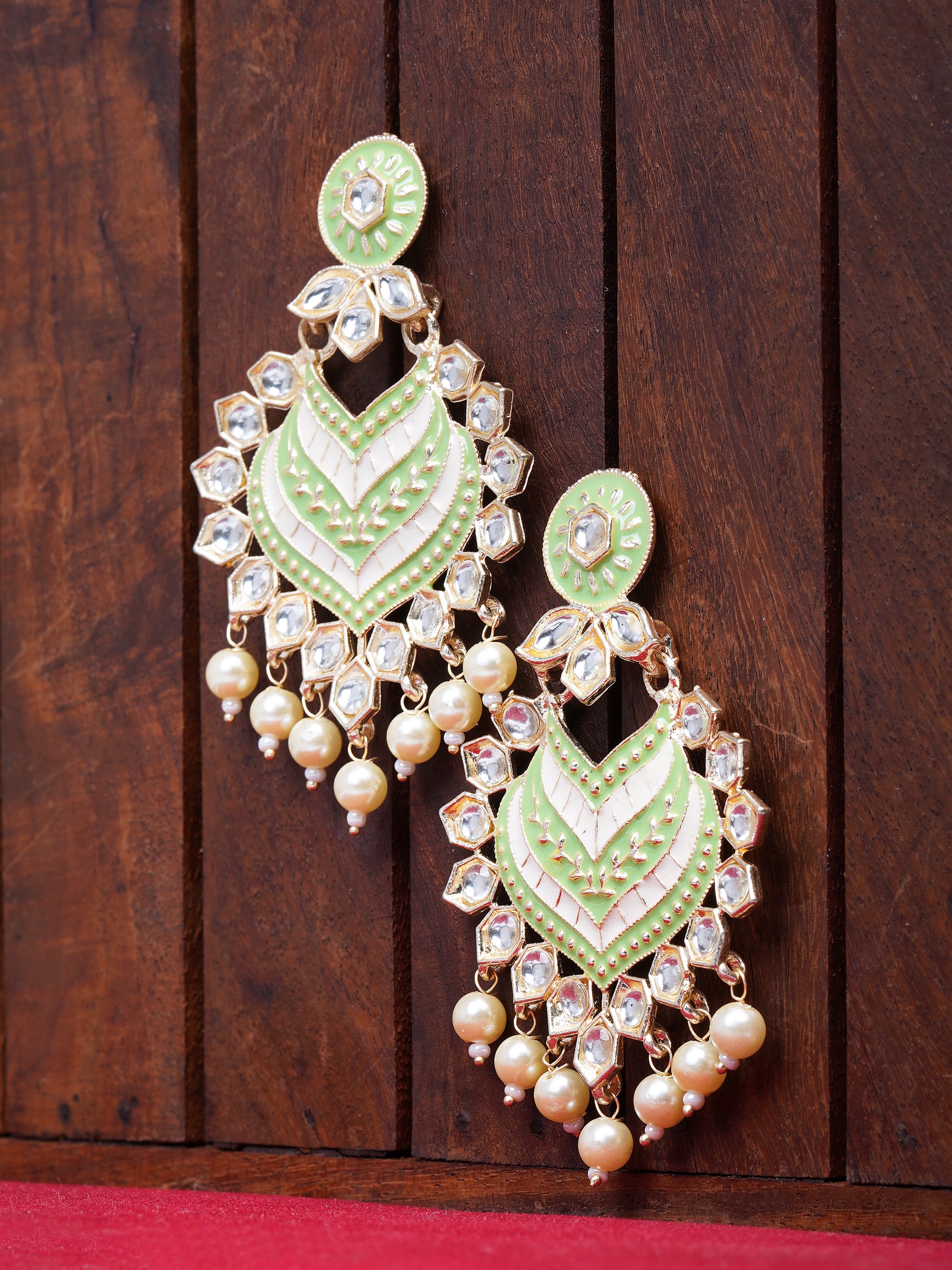 green kundan earrings brown background