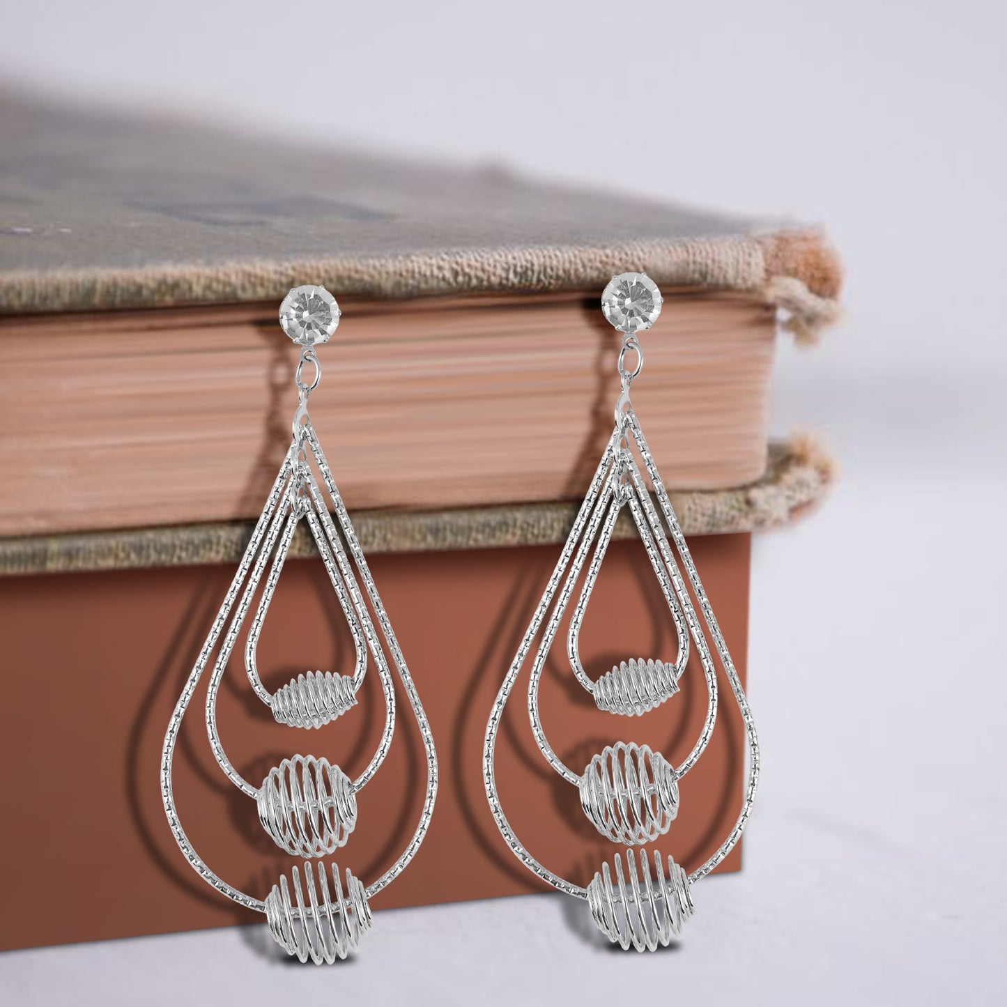 silver plated dangler earrings book background