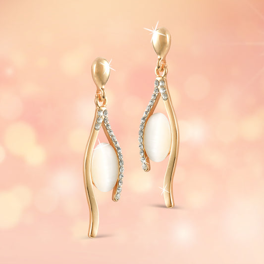 gold crystal drop earrings light peach background