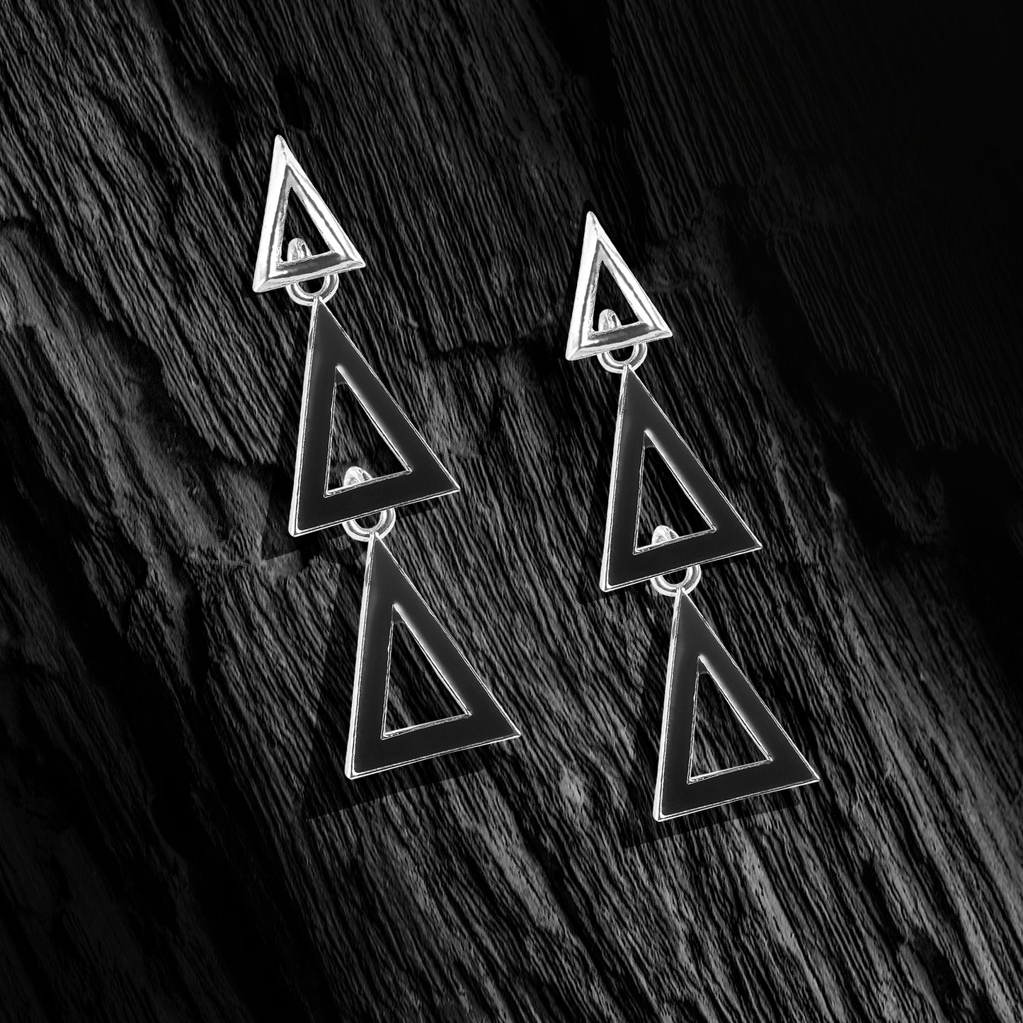 silver dangling triangle stud earrings black background