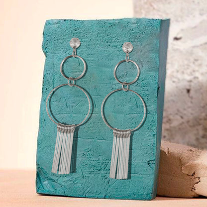 silver fringed dangle earrings green background