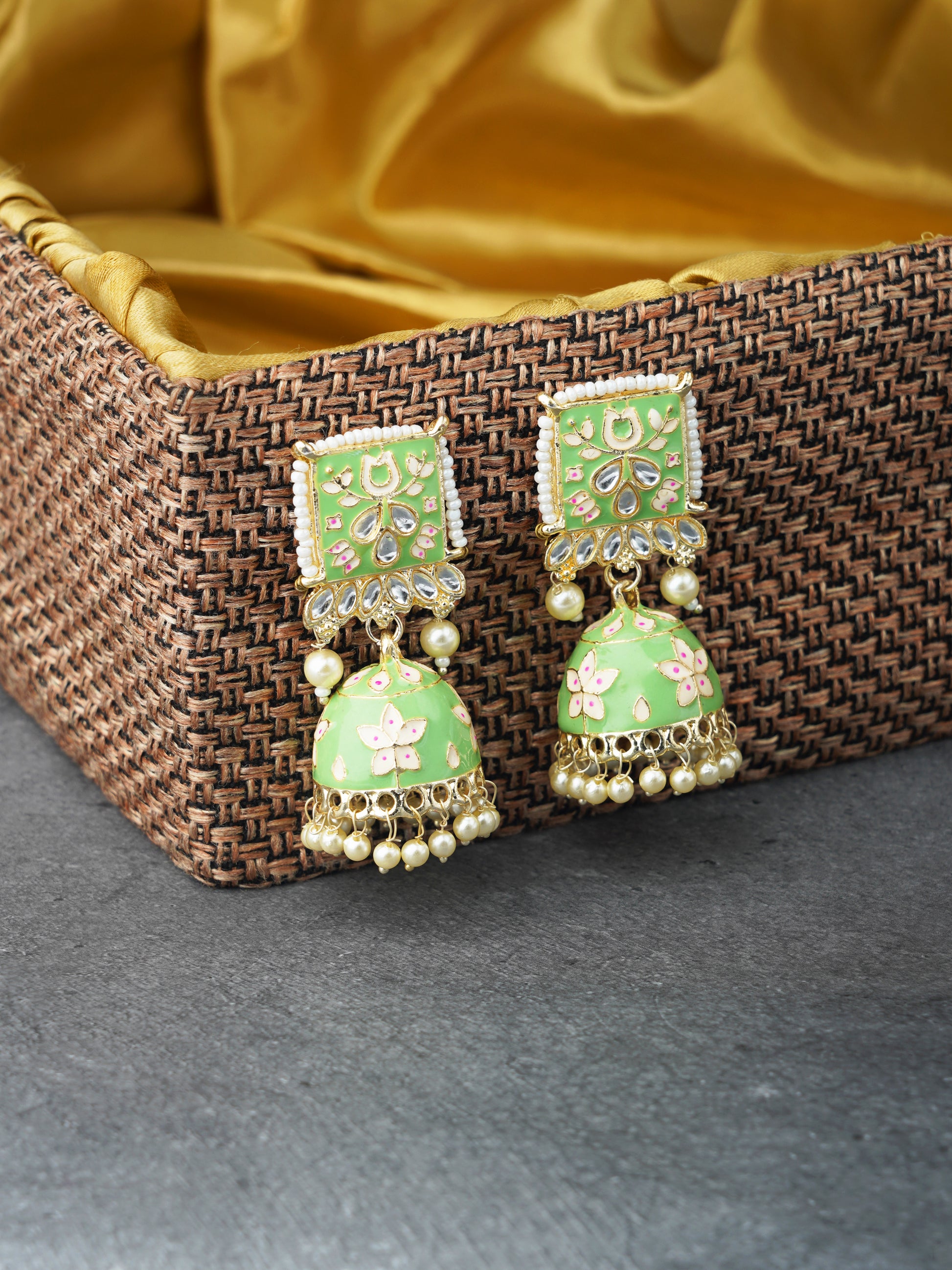 minakari green jhumka earrings brown background