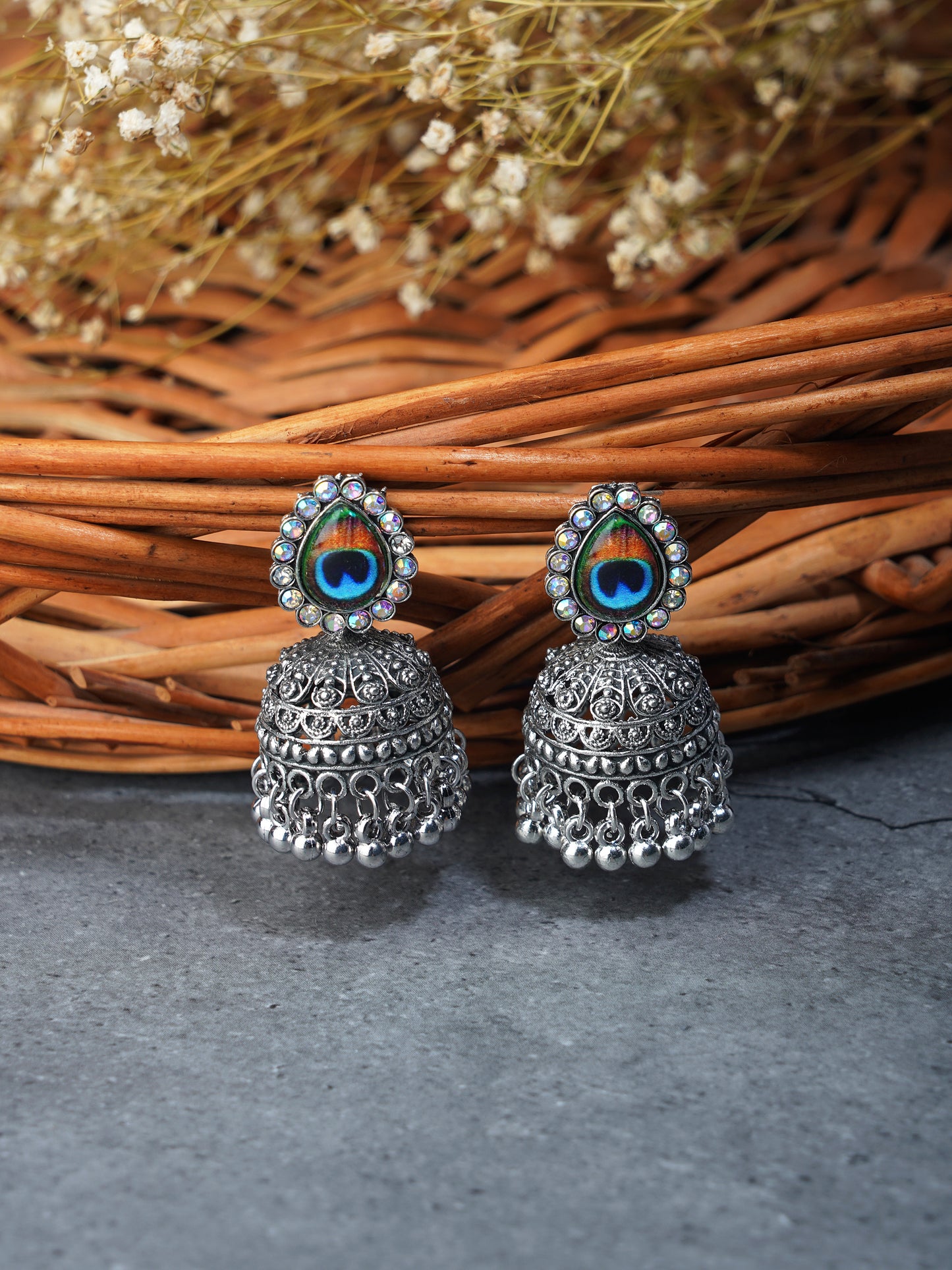 silver oxidised peacock feather jhumka  wooden background