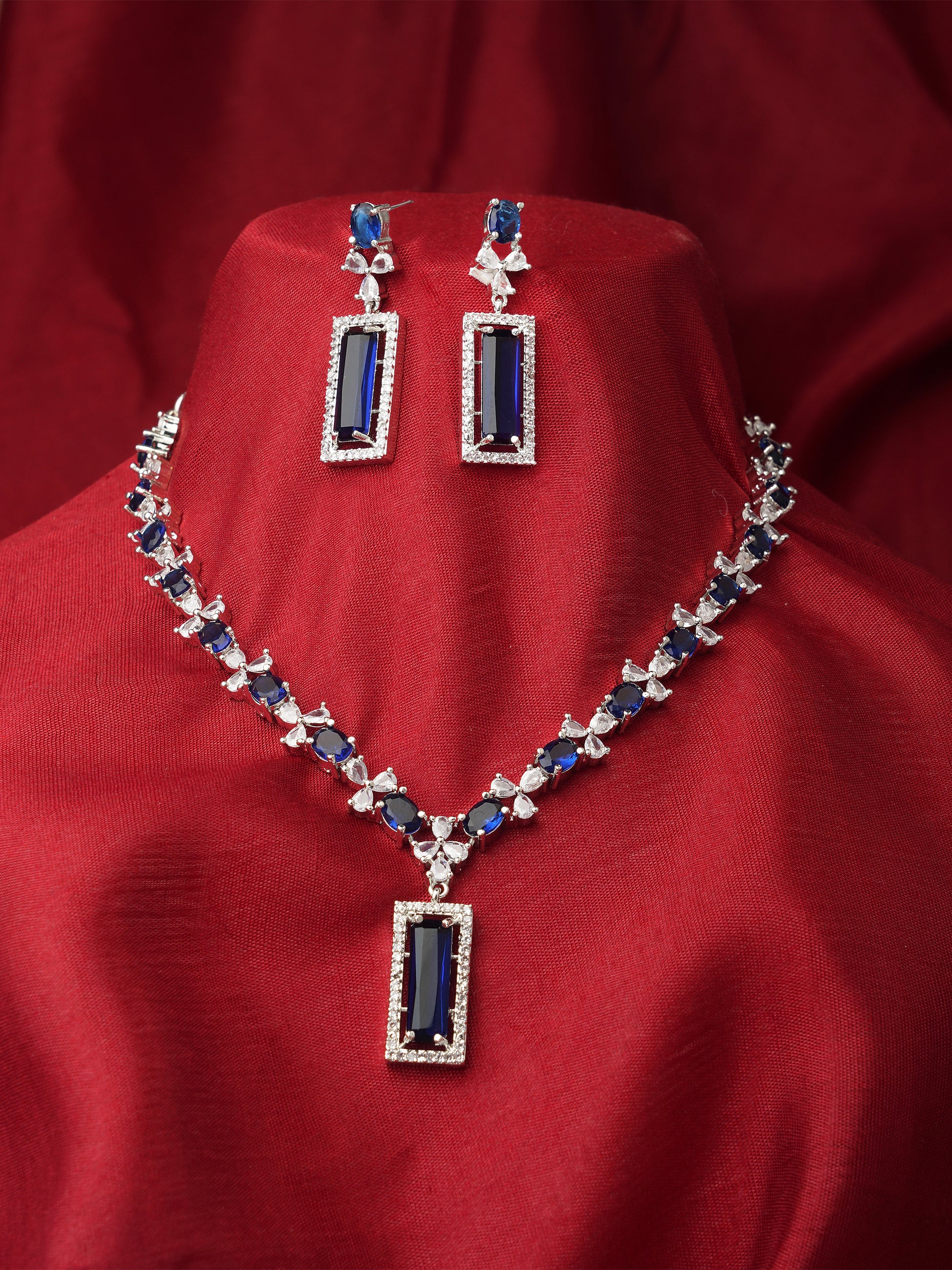 silver plated american diamond blue necklace red background