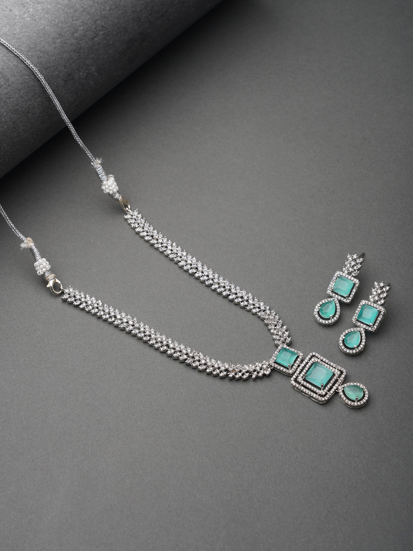 mint green american diamond necklace grey background