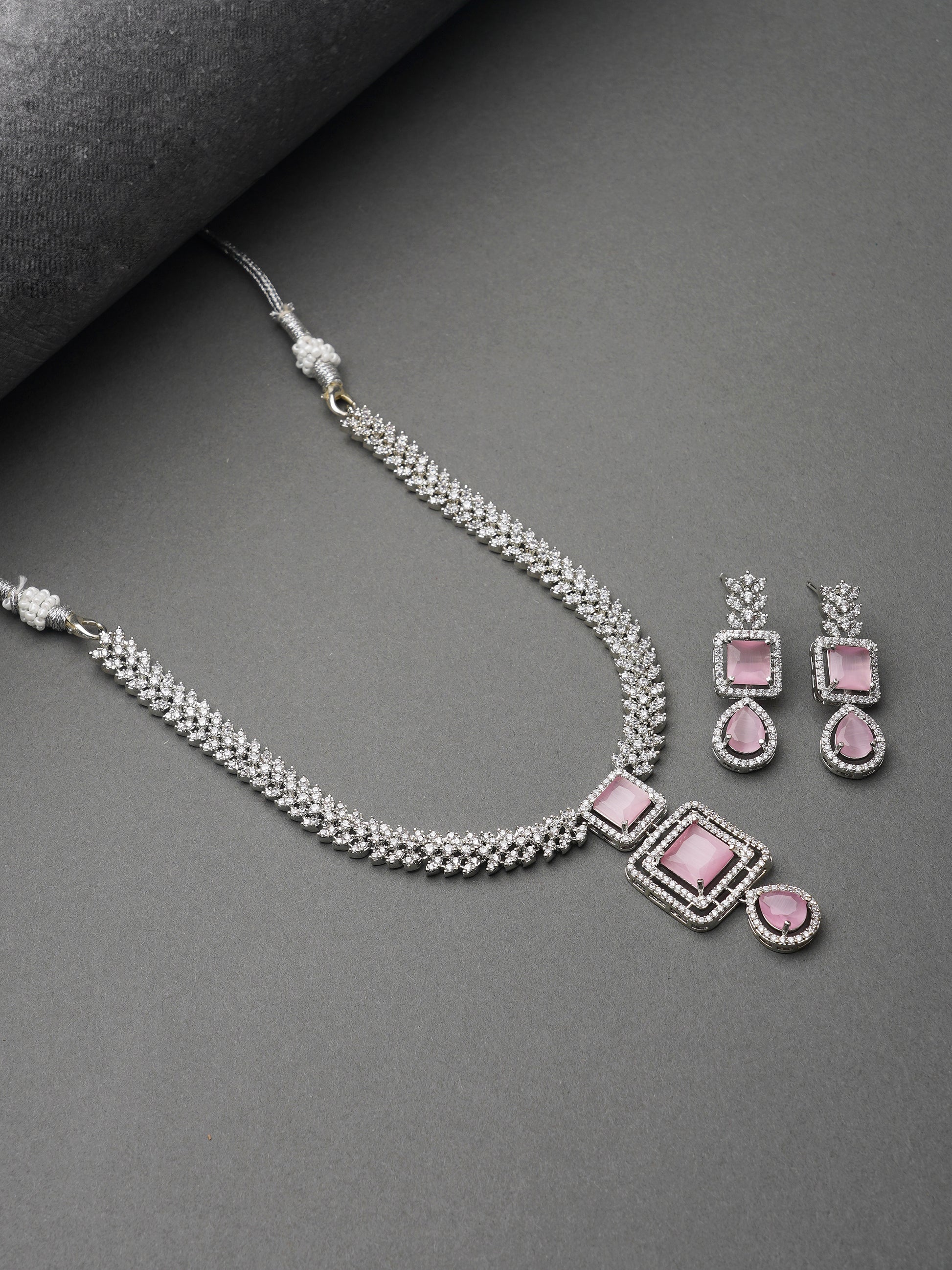 light pink american diamond necklace grey background